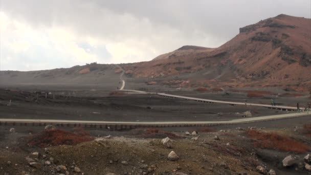Mensen lopen richting de Asosan-vulkaan. — Stockvideo