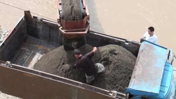 Un hombre pala arena en un camión . — Vídeos de Stock