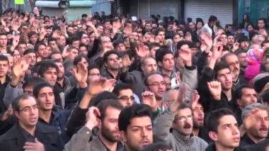 İnsanlar kasvetli bir geçit törenine katılıyorlar.