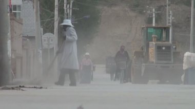 Bir kadın Xiahe sokakları süpürür.