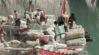 İnsanlar gemilere çanta yüklerler.