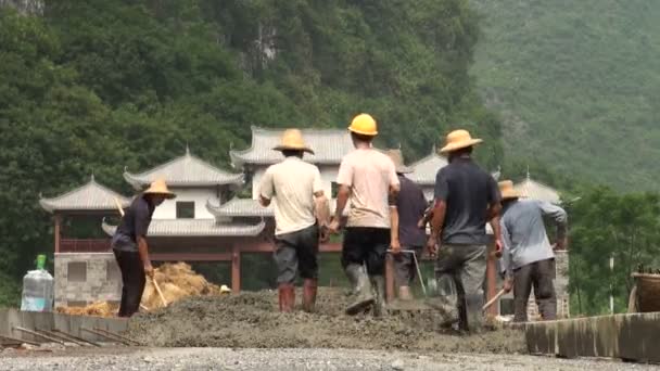 Mannen werken op de weg in landelijk China. — Stockvideo