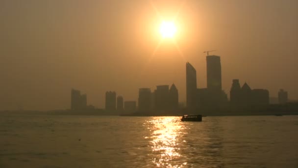 Ein Boot segelt vor der Skyline von Qingdao. — Stockvideo