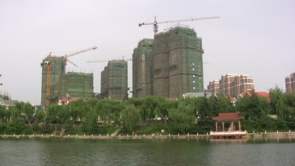 Budovy jsou ve výstavbě za jezerem — Stock video