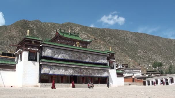 Los monjes pasan por el monasterio de Labrang . — Vídeo de stock