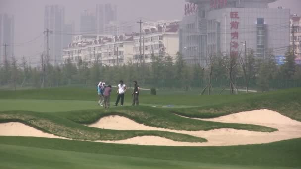 La gente juega golf en una ciudad china . — Vídeos de Stock