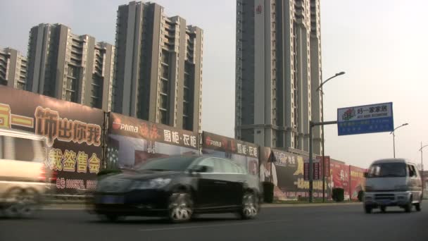 Verkeer rijdt langs een bouwplaats in China. — Stockvideo