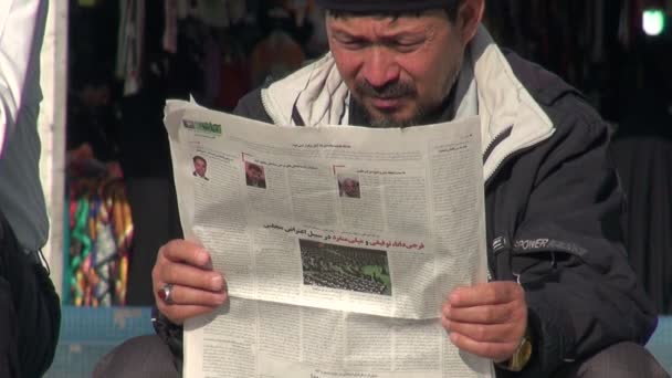 Um homem lê um jornal nas ruas de Qom . — Vídeo de Stock