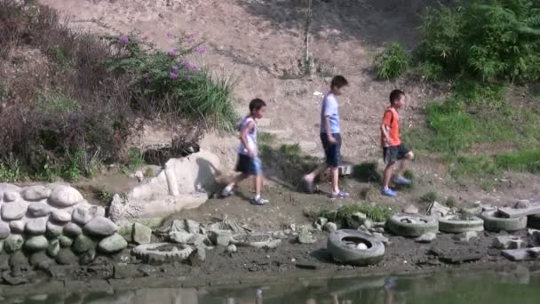 I bambini giocano a fianco di un torrente inquinato — Video Stock