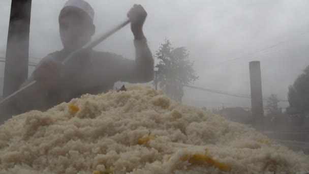 Člověk připraví čerstvé pilaf v Kašgar. — Stock video