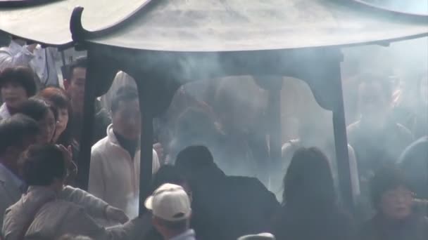 People gather to burn incense in temple — Stock Video