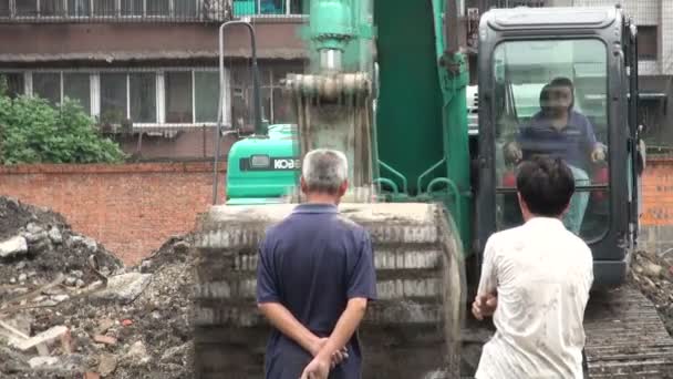 Mensen kijken naar een graafmachine — Stockvideo