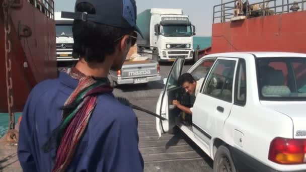 A crew member guides cars off a ferry — Stock Video