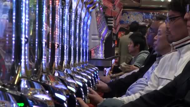 Menschen spielen auf Pachinko-Maschinen — Stockvideo