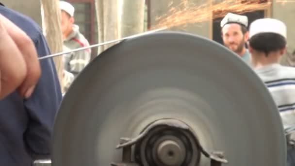 Man is sharpening knife in Xinjiang village. — Stock Video