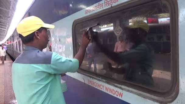 Un empleado limpia la ventana de un tren — Vídeo de stock