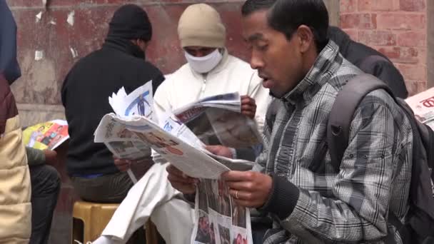 Мужчины читают газеты на улице Катманду — стоковое видео
