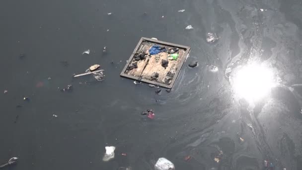 La spazzatura galleggia attraverso un fiume inquinato — Video Stock