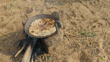 Bir parça chapati ekmeği ocakta pişirir.