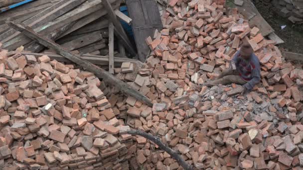Niezidentyfikowany człowiek skrobuje i czyści cegły — Wideo stockowe