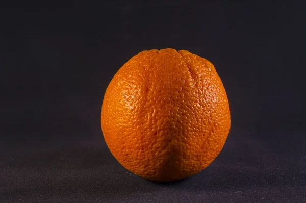 Laranja grande em um fundo preto . — Fotografia de Stock