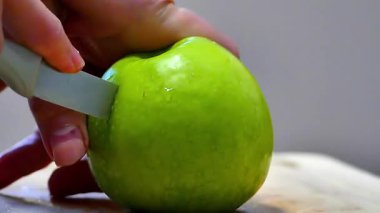 Mutfakta yeşil elma kesiyor..