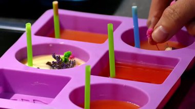 Kurumuş çiçekler sıvı balmumuyla kalıplara konur..