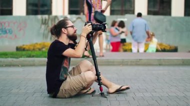 Yol fotoğrafçı üzerinde oturan ve insanlar fotoğraflandı sakallı adam