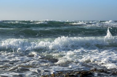 Deniz köpüklü deniz dalgaları kayalık kıyılara çarpar..