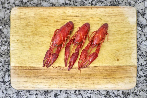 Red lobsters on cutting board — Stock Photo, Image