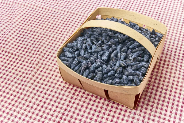 Kamperfoelie bessen vruchten in een houten mandje — Stockfoto