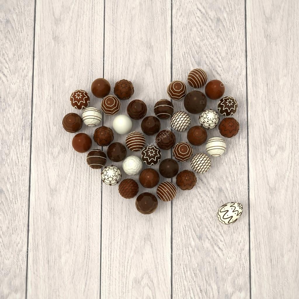 Chocolate Easter eggs heart on white wooden floor - top view