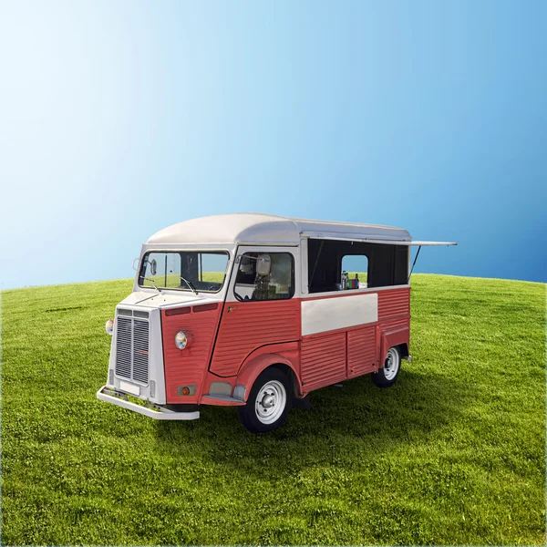 Red food truck on the green field — Stock Photo, Image