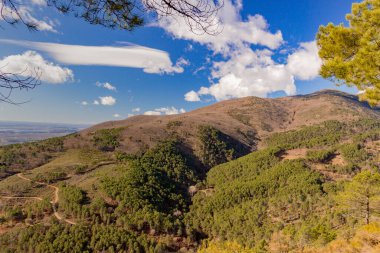 Alçak dağ manzarası. Mavi gökyüzü, biraz bulut ve güneşli bir gün.