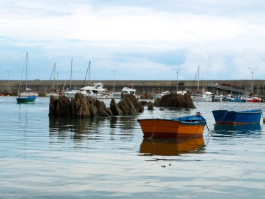 Dalgakıran ve kayalarla dolu bir tekne limanı.