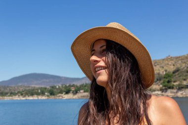 Gölde gülümseyen şapkalı genç bir kız. Yaz. Seçici odak.