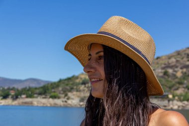 Gölde gülümseyen şapkalı genç bir kız. Yaz. Seçici odak.