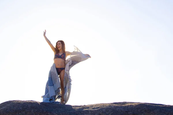 Chica Joven Bikini Sosteniendo Una Toalla Saludando Sobre Una Roca — Foto de Stock