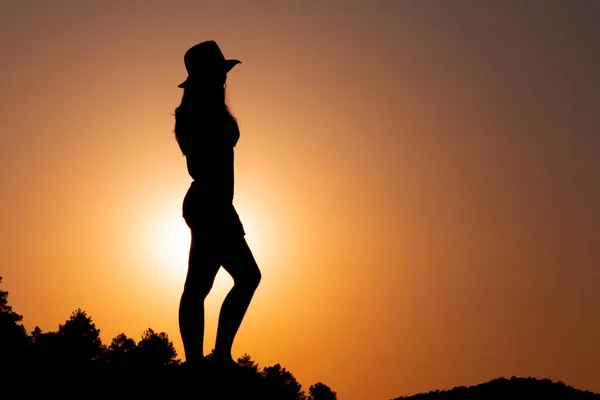 日落时的女性轮廓 面对着太阳 头戴一顶帽子 有选择的重点 复制空间 — 图库照片
