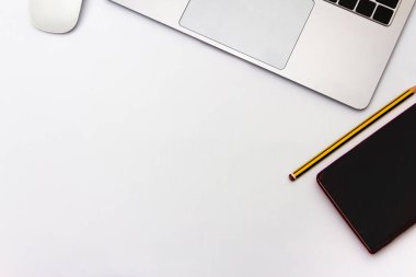 Beyaz zemin üzerinde fare, defter ve kalem olan dizüstü bilgisayar. Ofis kavramı. Üst Manzara. Düz yatıyordu. Boşluğu kopyala.
