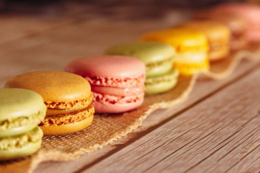 Ahşap üzerine pastel renkte Fransız badem kurabiyesi. Uzayı kopyala Seçici odak.