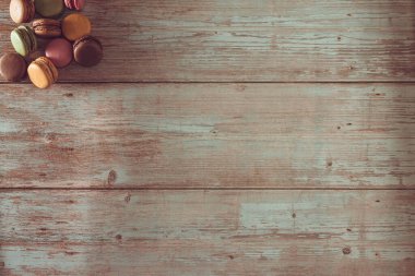 Ahşap üzerine pastel renkte Fransız badem kurabiyesi. Uzayı kopyala Seçici odak.