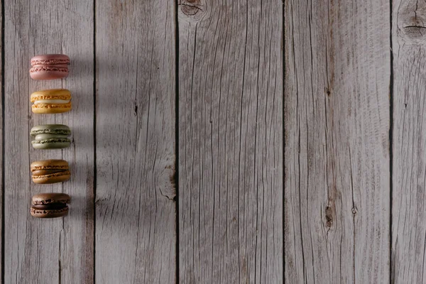 Ahşap üzerine pastel renkte Fransız badem kurabiyesi. Uzayı kopyala Seçici odak.