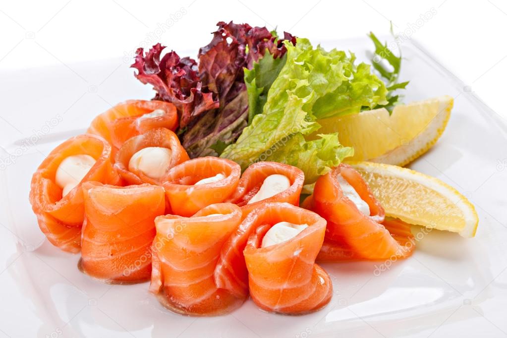 Sliced salted salmon rolled with cheese sauce served with lemon.