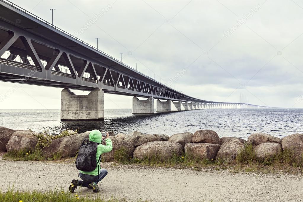 Female tourist taking pictures the Oresund bridge.