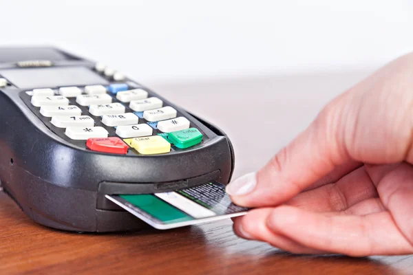 Mão empurrar cartão de crédito em uma máquina de cartão de crédito . — Fotografia de Stock
