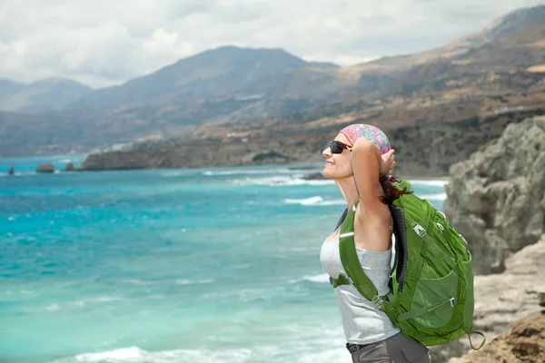 Жінка-туристка з рюкзаком на узбережжі моря насолоджується подорожами — стокове фото
