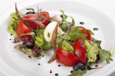 Italian salad with mozzarella cheese, tomato, olives and herbs.