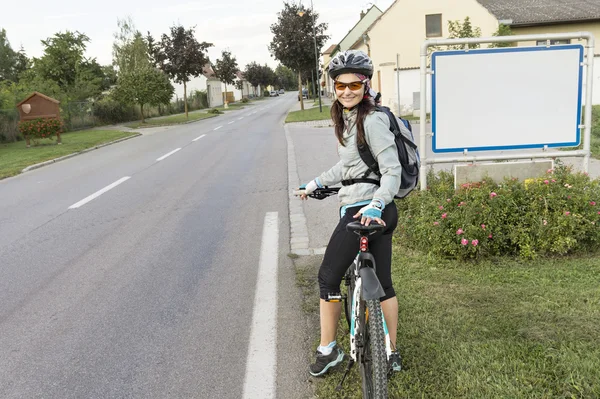Glückliche Radfahrerin blickt in die Kamera und lächelt. — Stockfoto