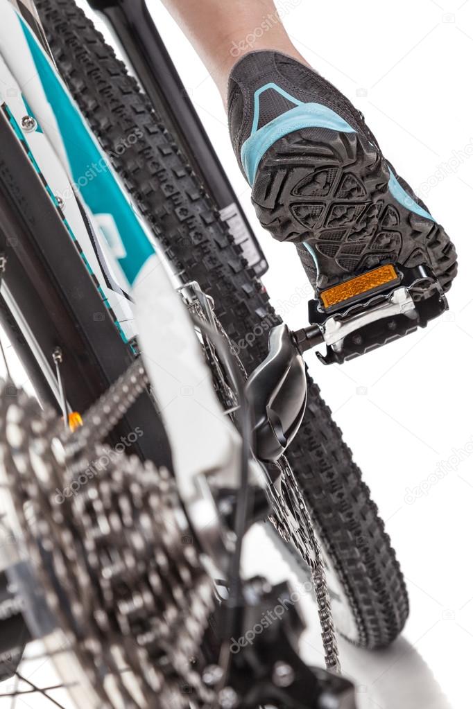 Close up rear view cyclist pedalling mountain bike.